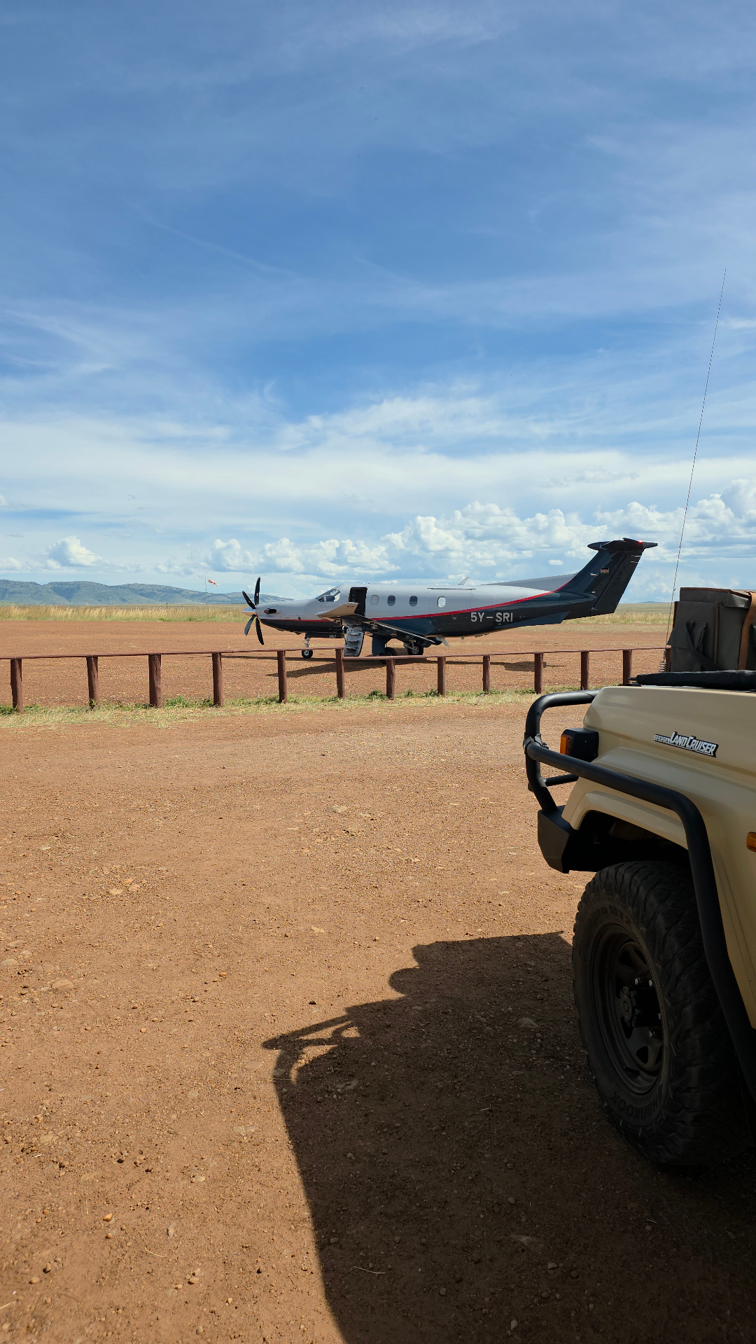 Pilatus PC-12 5Y-SRI on a Kenyan bush airstrip with a Land Cruiser in the foreground