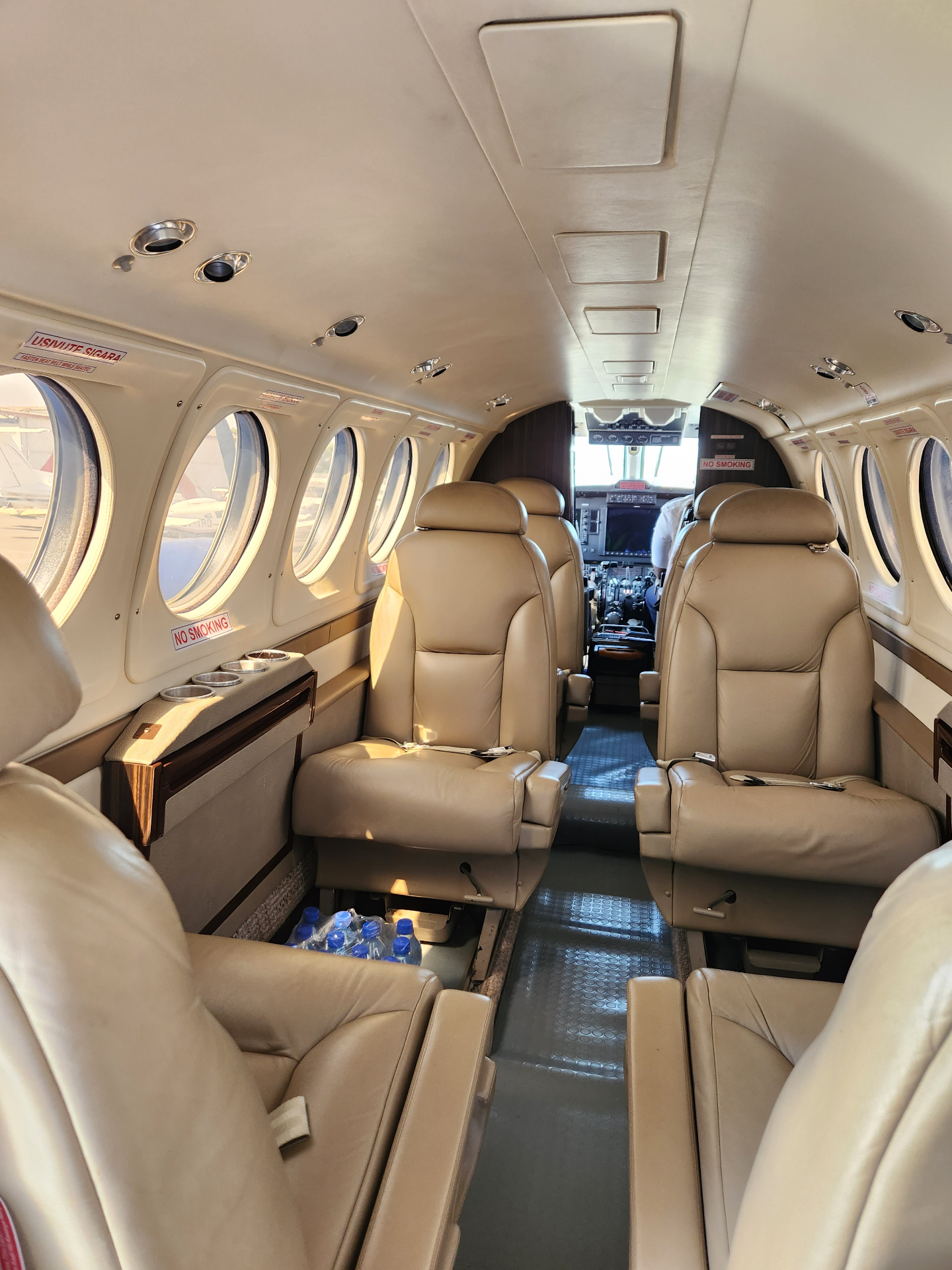 Beechcraft King Air B200 executive cabin with tan leather club seating and burl wood trim